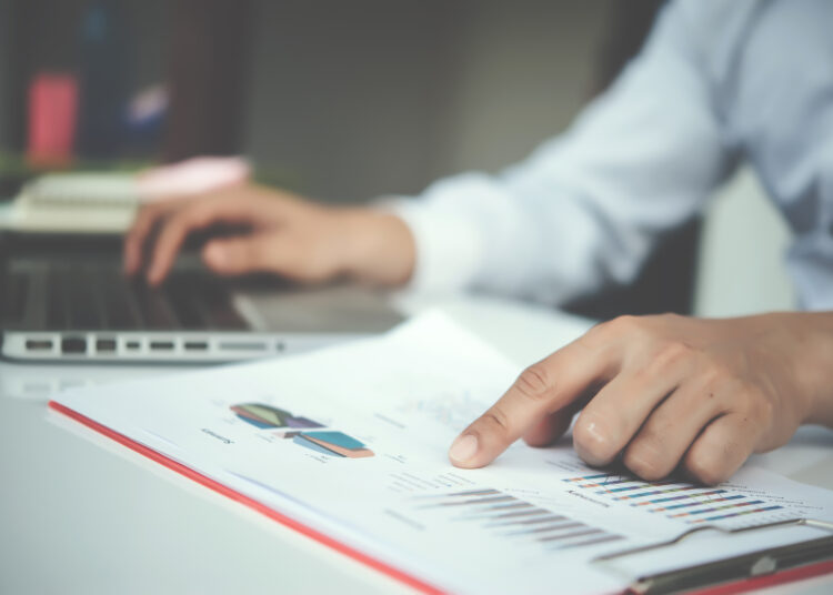 Portrait of young business man sitting at his desk in the office